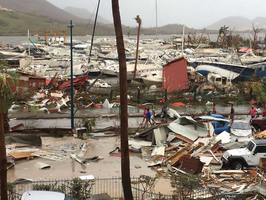 Locals Walk Through The Ruins Of A Harbour Area On The Island Of Saint Martin After The Hurricane Left It In Ruins