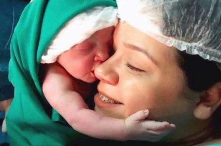 Bé gái mới chào đời đã vừa khóc vừa ôm chặt lấy mặt mẹ (Video)