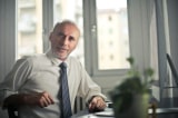 man sitting on chair beside table 834863