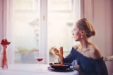 woman sitting on chair while eating pasta dish 1456262