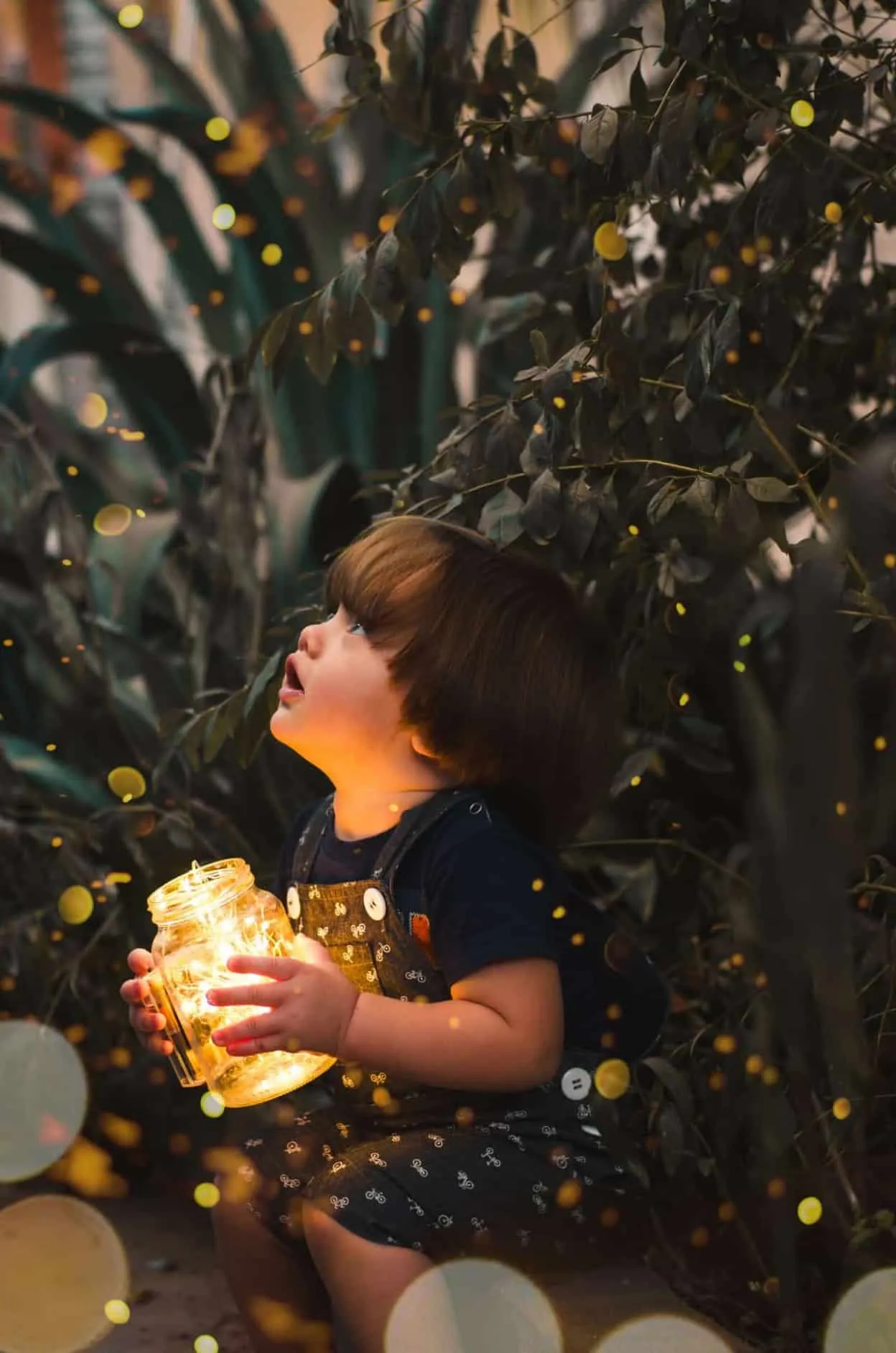 child holding clear glass jar with yellow light 2026960 image