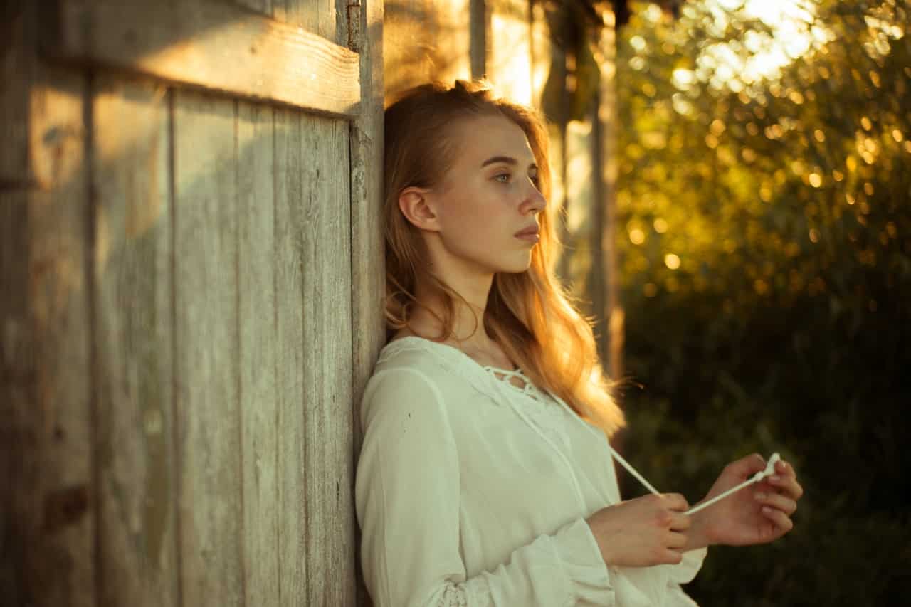 woman wearing white top leaning on wooden wall 2726046 image