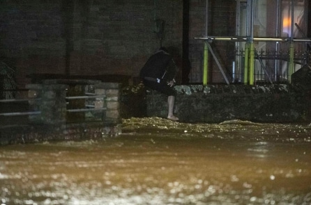 Người đàn ông lội xuống vùng nước cao đến ngực giải cứu tài xế mắc kẹt