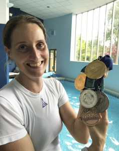 Melanie Barratt with her haul from the 1996 and 200 Paralympics credit SWNS