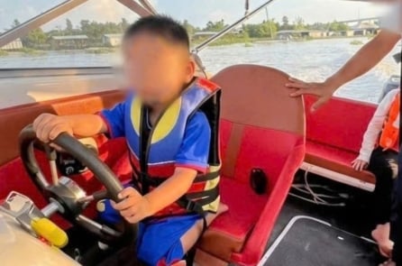 Người cha để con trai 3 tuổi cầm lái cano
